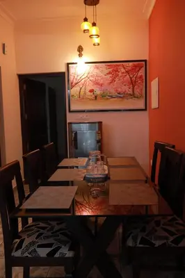 a dining room with a table and a painting on the wall at AVANTI CASTELLO in Guruvāyūr