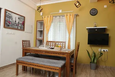 a dining room table with chairs and a television at AVANTI CASTELLO in Guruvāyūr