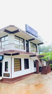 a building with a sign on top of it at Hotel Caveri Inn in Madikeri
