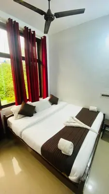 a large bed in a room with a window at Hotel Caveri Inn in Madikeri