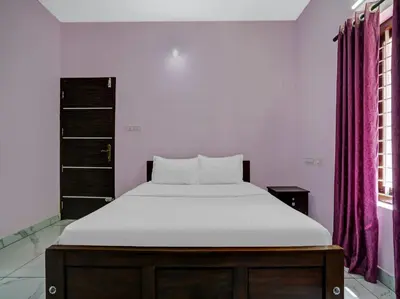 a bedroom with a bed with a white mattress at Shalom Palace Residency in Neriyamangalam