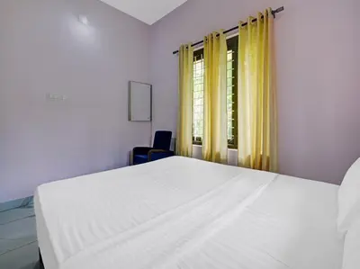 a white bed in a room with a window at Shalom Palace Residency in Neriyamangalam