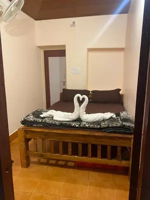 two swans sitting on a bed in a room at Mercara Aloft in Madikeri