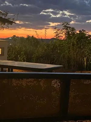 a picnic table with the sunset in the background at Mercara Aloft in Madikeri