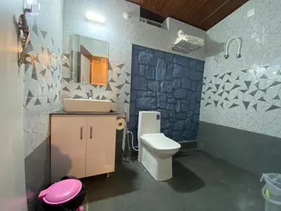 a bathroom with a toilet and a sink and a mirror at Mercara Aloft in Madikeri
