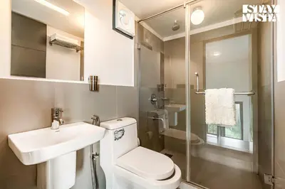 a bathroom with a toilet and a sink and a shower at StayVista at Griha Sankalpa with Mountain View, BBQ Wayanad in Koroth