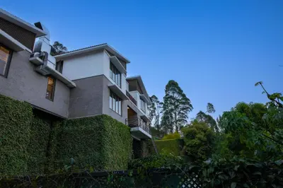 an ivy covered building next to a building at Dvara Luxury Resort Kodaikanal in Kodaikānāl