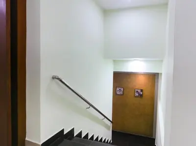 a staircase in a building with a metal hand rail at HOTEL NEWCASTLE in Vadakkāncheri