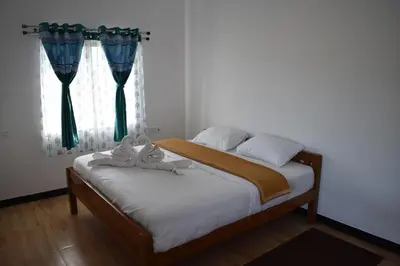 a bedroom with a bed and a window with curtains at DIAMOND HILL VIEW in Ketti