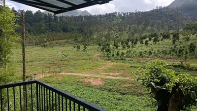 a view of a field from the balcony of a house at Teaside Inns in Vythiri
