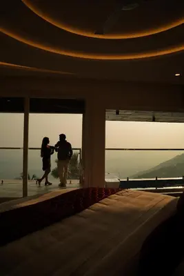 two people standing in a building looking at the view at Mount Stratus Resort Vayalada in Bālūssheri