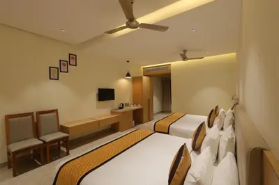 a hotel room with two beds and a television at Hotel Nakshathra- A Royal Stay in Palani