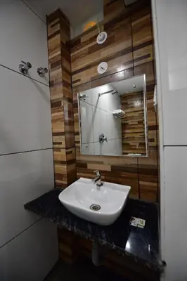a bathroom with a sink and a mirror at Hotel Surya Lodge in Mysore