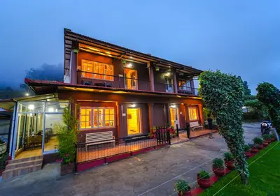 a large house with a porch and a balcony at SILENT VALLEY FARMSTEAD OOTY by VOYE HOMES in Ooty
