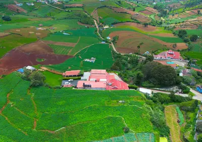 an aerial view of a farm in a field at SILENT VALLEY FARMSTEAD OOTY by VOYE HOMES in Ooty