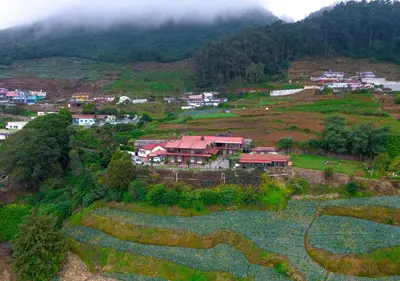 an aerial view of a village on a hill at SILENT VALLEY FARMSTEAD OOTY by VOYE HOMES in Ooty