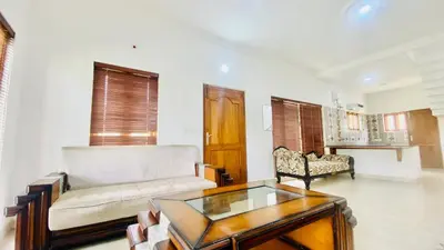 a living room with a couch and a coffee table at Mountain Mansion Kodai in Kodaikānāl