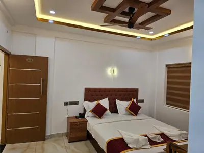 a bedroom with a large bed and a ceiling at MARINA SUITES AIRPORT HOTEL in Cochin