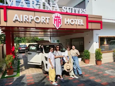 a group of people standing in front of an airport hotel at MARINA SUITES AIRPORT HOTEL in Cochin
