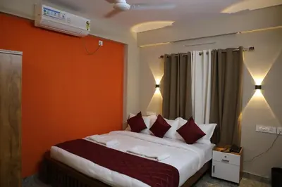 a bedroom with a large bed with red pillows at Dreams Paradise Airport Residency in Nedumbassery