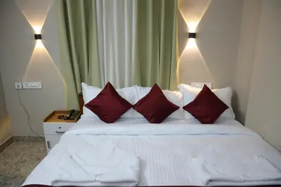 a bedroom with a white bed with red pillows at Dreams Paradise Airport Residency in Nedumbassery
