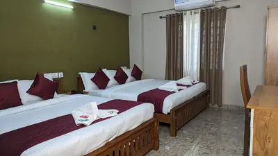 a hotel room with two beds with towels on them at Dreams Paradise Airport Residency in Nedumbassery