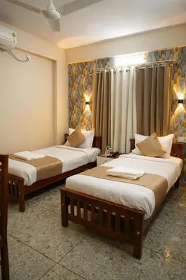 a hotel room with two beds and a window at Dreams Paradise Airport Residency in Nedumbassery