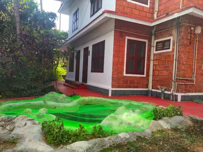 a house with a green blanket in front of it at Navarang Villa in Kalpetta