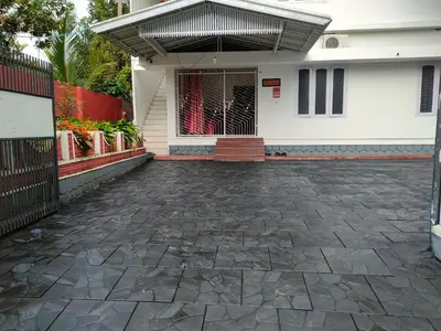 a house with a stone driveway leading to the front door at Navarang Villa in Kalpetta