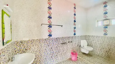 a bathroom with a toilet and a sink at Mountain Abode in Kodaikānāl