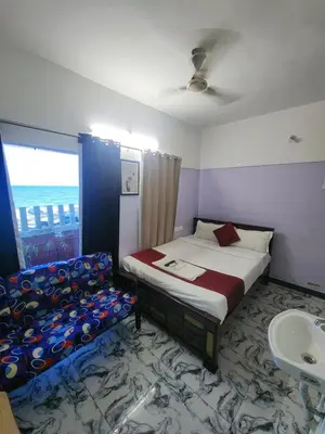 a bedroom with a bed and a sink and a window at Paradise Harmony Beach Resort in Singānallūr