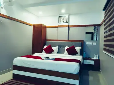 a bedroom with a large bed with red and white pillows at The Rosetta Castle in Kalpetta
