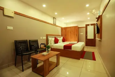 a bedroom with a bed and a table and a chair at The Rosetta Castle in Kalpetta