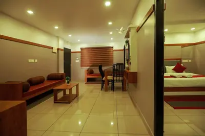 a living room with a bed and a dining room at The Rosetta Castle in Kalpetta