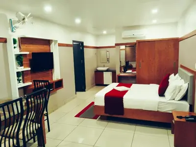 a hotel room with a bed and a kitchen at The Rosetta Castle in Kalpetta