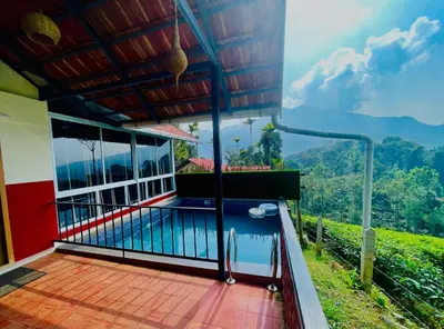 a balcony of a house with a swimming pool at Mayflower Holiday Villa in Meppādi