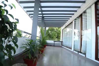 a balcony with plants and a table and windows at hazmi inn in Perintalmanna