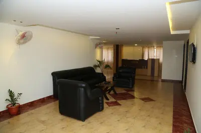 a living room with a couch and two chairs at hazmi inn in Perintalmanna