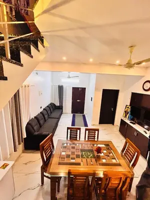 a living room with a table and a couch at ENOCEAN HOMESTAY in Cherai Beach