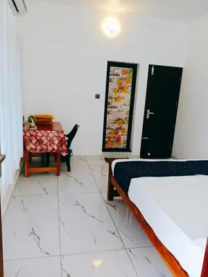a room with a bed and a table and a mirror at ENOCEAN HOMESTAY in Cherai Beach