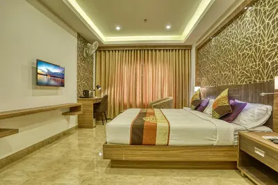 a bedroom with a bed and a desk in it at VKJ INTERNATIONAL in Perumbavoor