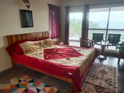 a bedroom with a bed and a large window at MOUNTAIN OF MAGICS in Ooty