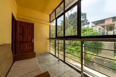 an empty room with a large window and a door at MARZA INN in Kalpetta