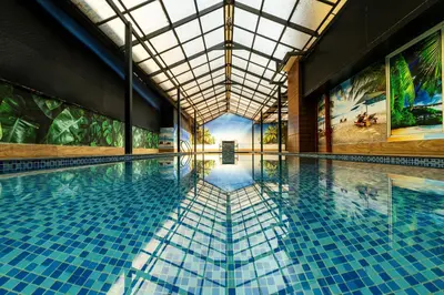 a large swimming pool with a large ceiling at MARZA INN in Kalpetta