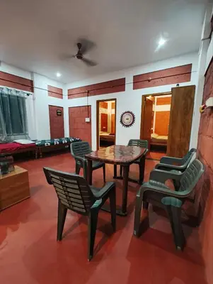 a room with a table and chairs and a couch at Amberleaf Estate 4BHK Homestay Coorg by Homeyhuts in Virajpet