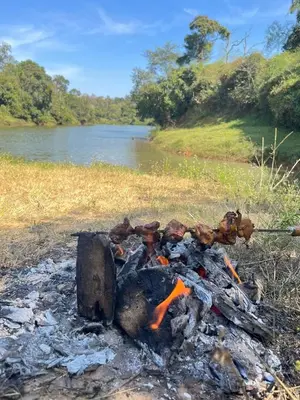 a camp fire on the side of a river at Amberleaf Estate 4BHK Homestay Coorg by Homeyhuts in Virajpet