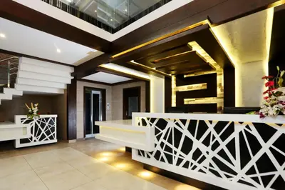 a lobby of a hotel with a staircase and flowers at moriz inz in Mysore
