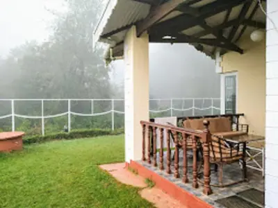 a porch of a house with a fence at Dew Drops Cottage Coonoor By Lexstays in Coonoor