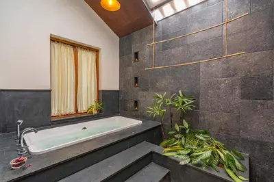 a bathroom with a bath tub and a window at StayVista at Mountain Rain - Breakfast Included in Wayanad