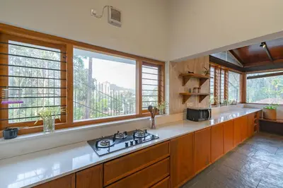 a kitchen with a stove and some windows at StayVista at Mountain Rain - Breakfast Included in Wayanad